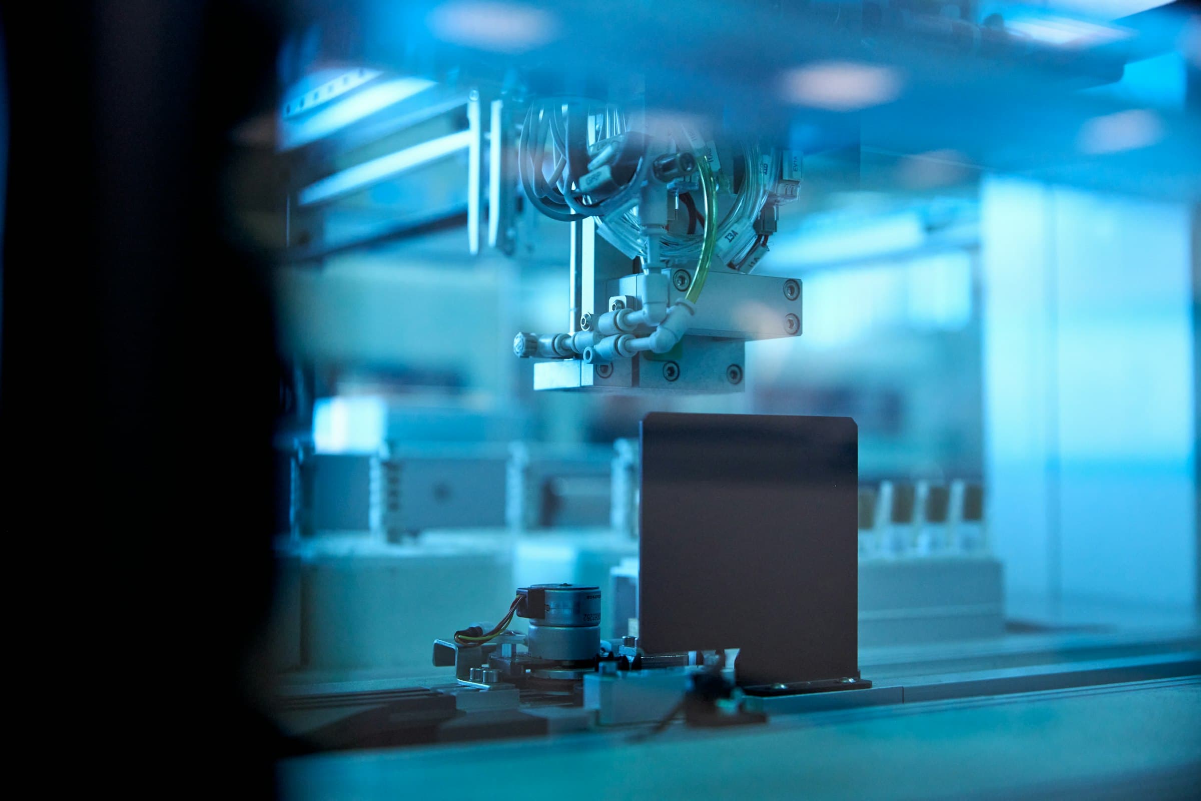 Robotic arm working on an automated production line in blue light
